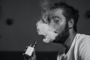 grayscale photo of man vaping