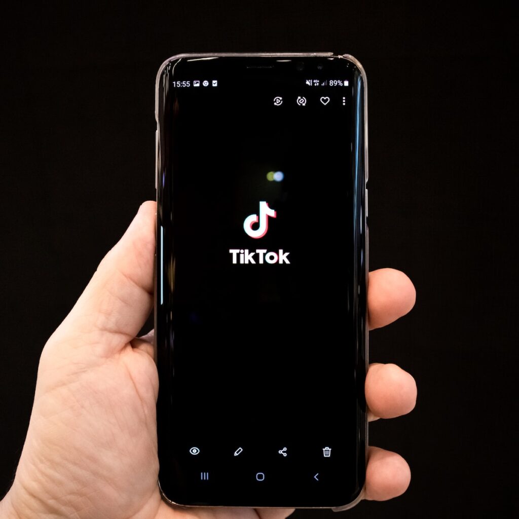 black android smartphone displaying 12 00 Tiltok App 抖音