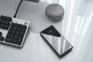 black Android smartphone near computer keyboard
