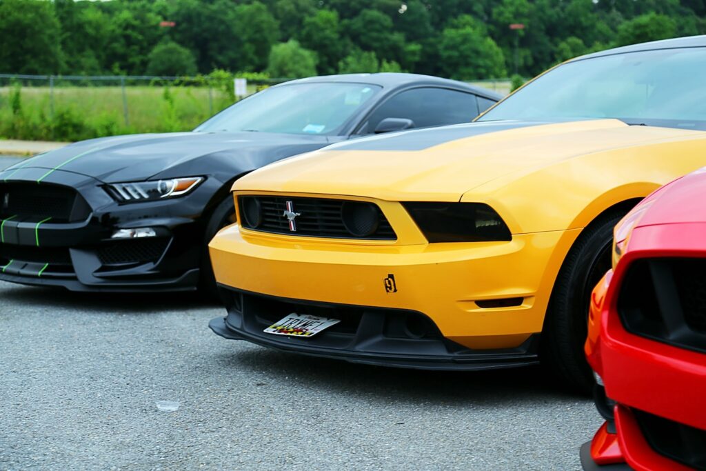 parked yellow Ford Mustang coupe and black