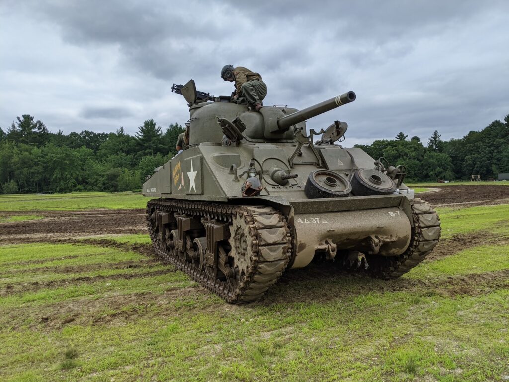 a military tank sitting on top of a lush green field