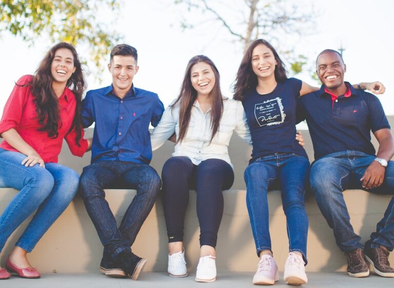 group of people sitting on bench near trees duting daytime