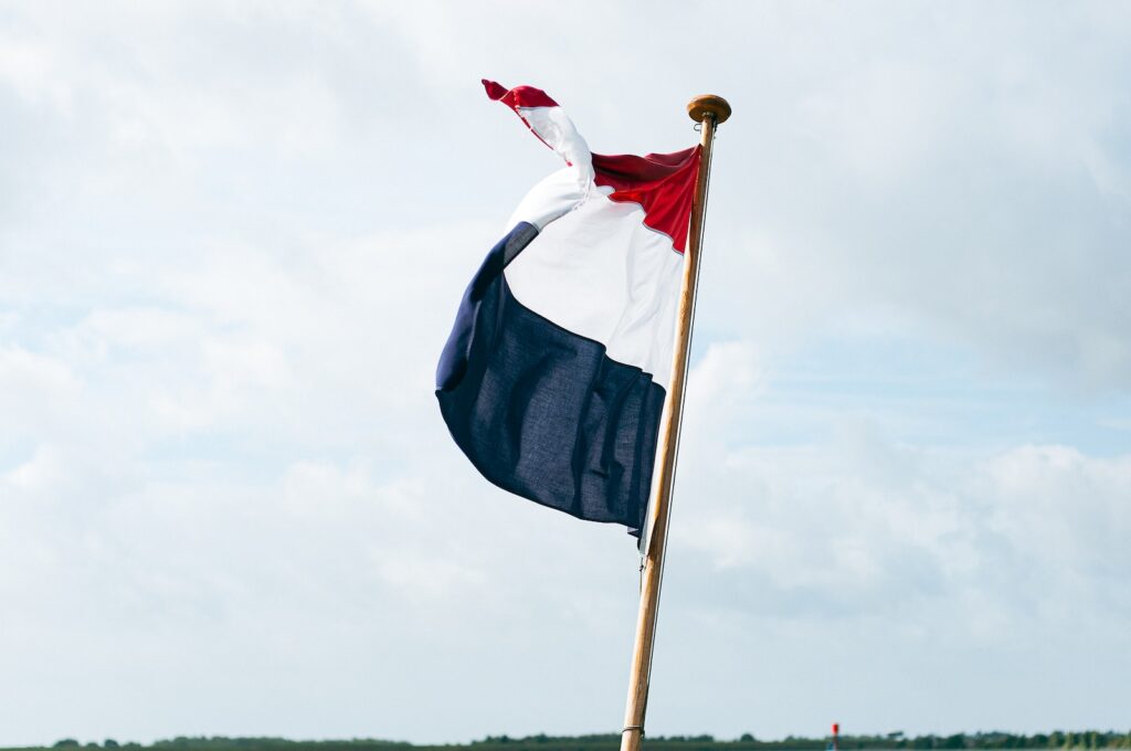flag of us a on pole under white clouds