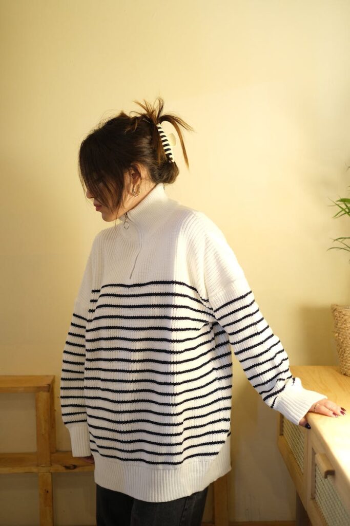 Woman in Striped Long Sleeve Shirt Near the Sideboard