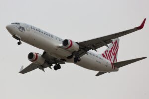 white and red air plane in mid air during daytime