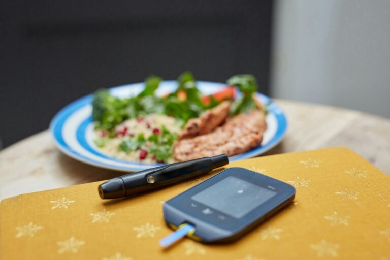 a plate of food and a Glucometer on a table