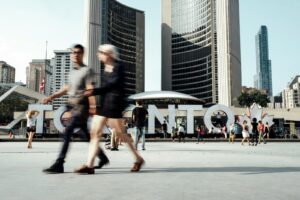 加拿大多倫多 two man and woman walking on pathway near high rise buildings