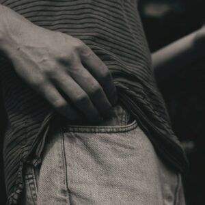 person in black and white striped long sleeve shirt and gray denim jeans